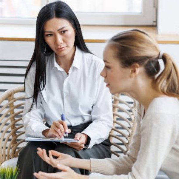 Concept of mental health. Session at phycologist. Patient and doctor in the cabinet. Young woman at phycologist, telling about problems and issues in her life. Looking sad and miserable